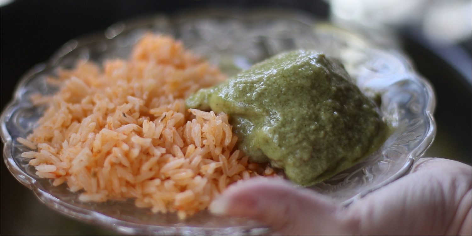 arroz rojo and mole verde held on a glass plate